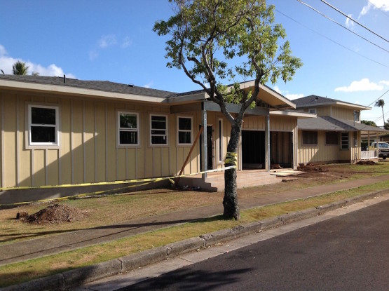 A cream colored house with a tree in front