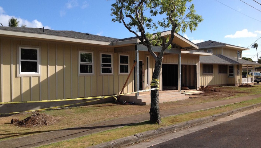 A cream colored house with a tree in front