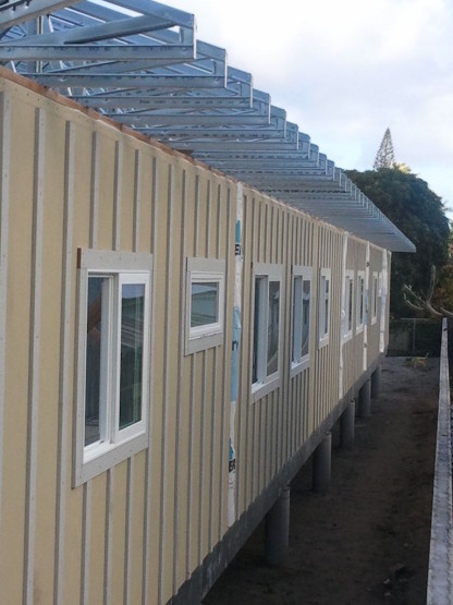 Many windows towards the side of a cream colored house