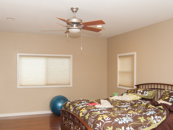 Bedroom inside a house with a designer fan