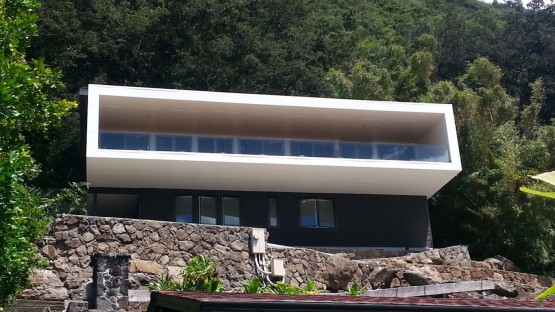 Black colored house with a white colored balcony