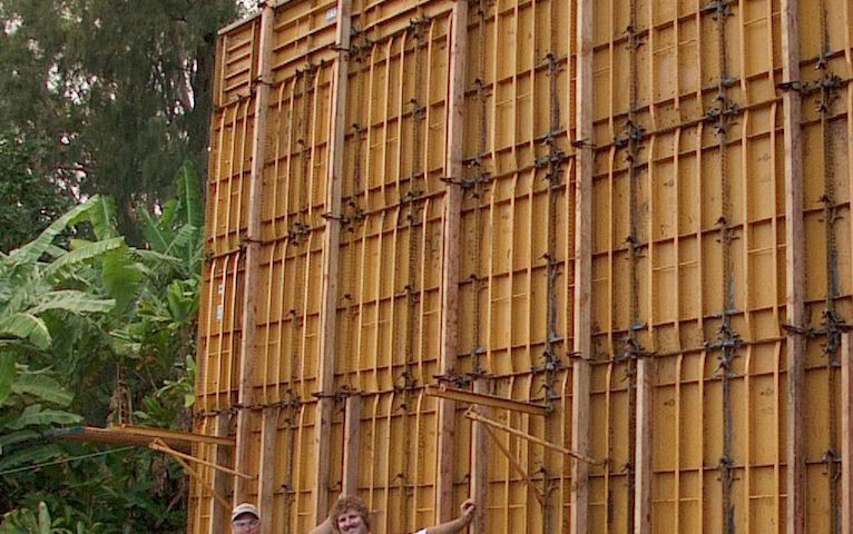 Two people posing near a metal board