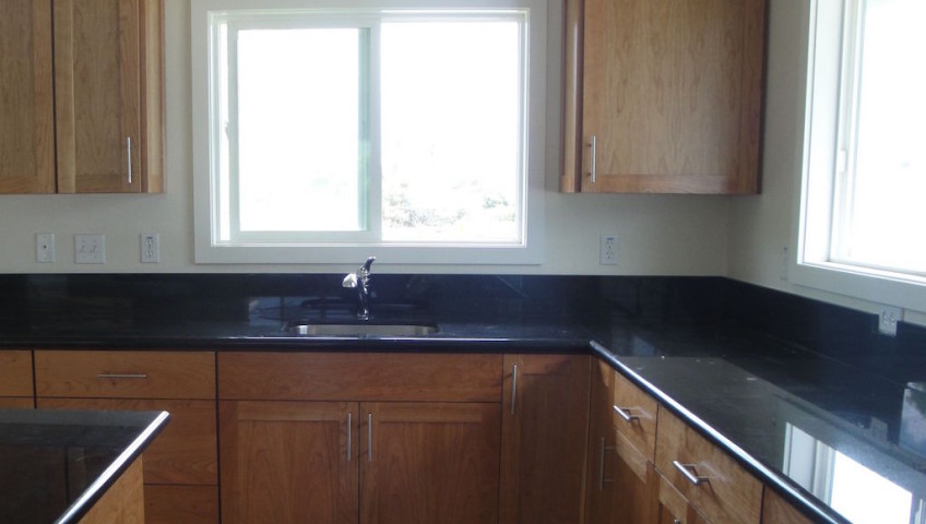 Wooden cabinets and black colored table top