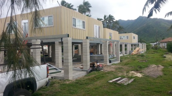 Three similar cream colored houses under construction